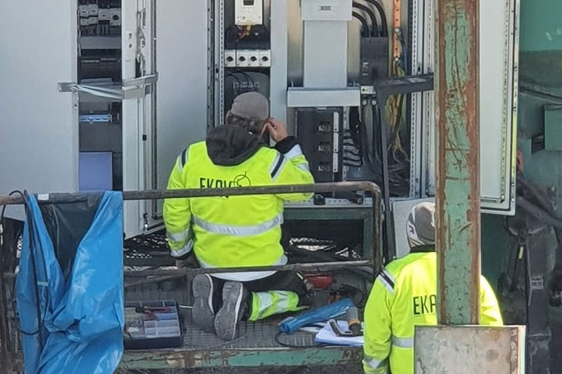 Två Anställda på EKAV som arbetar med elinstallation utomhus.